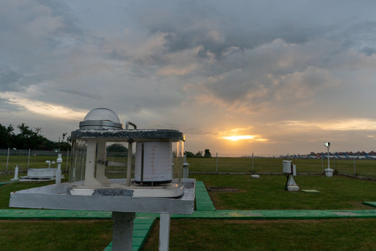 Pyranograph at meteorology field with green grass and when sunset under cloudy sky.