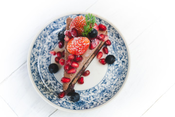 Chocolate cake topping with strawberry and berry fruits.