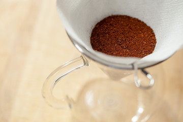 Ground coffee in dripper with paper filter. Kind of coffee brewing