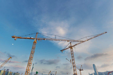 Crane in construction site with skyscraper background