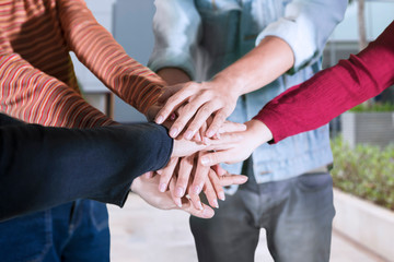 Young people showing teamwork gesture