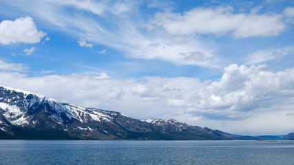 Fototapeta na wymiar snowy mountain and lake with cloudy sky