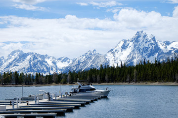 Boat in the lake with background of pine trees and snowy mountain