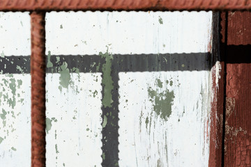 Old painted window behind iron bar close up. Grunge background