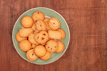 Danish butter cookies, shot from above on a dark rustic wooden background with copy space
