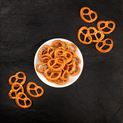Salty pretzels, shot from the top on a black background with copy space. Party snacks with a place for text