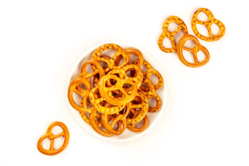 Salty pretzels, shot from above on a white background with copy space. Party snacks with a place...
