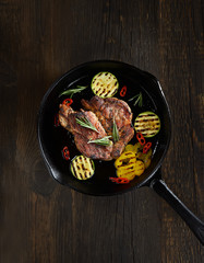 grilled steak in a pan on a wooden background
