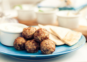 Fried minced meat with sauce and tortillas, traditional Greek lunch on a blue plate in a restaurantю
