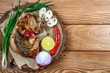 Roast whole rabbit on a wooden board on a dark background. A festive meal. The top view.. Flat lay. With copy space