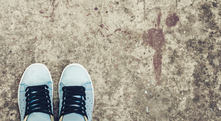 Sneakers of blue suede on the sidewalk.