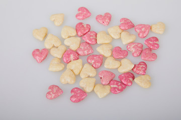 Fototapeta premium Mix of glazed, dry, pink and white heart shaped cereals breakfast on white background