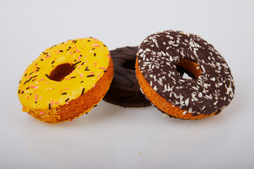assorted donuts with chocolate frosted, yellow glazed and sprinkles donuts. Sweet and colorful doughnuts