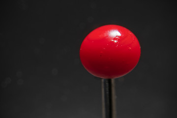 Indoor close-up photography of a red pinhead.