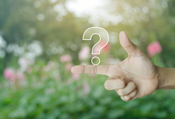 Question mark sign icon on finger over blur pink flower and tree in park, Business customer service...