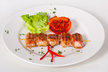 Skewers of grilled meat and vegetables on the white plate, Close up