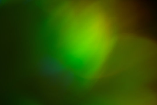 Blurred green and yellow lights. Bokeh abstract background with lens flare glow effect.