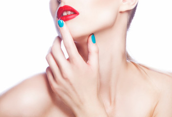 Bright red lips, hand finger with manicure near mouth, neck and shoulder of young model woman. Perfect skin, bright make-up. White background 