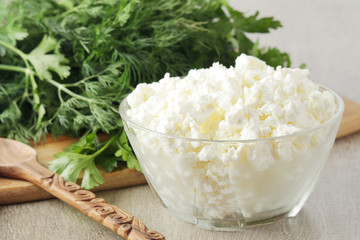 A bowl with cottage cheese and a bunch of green