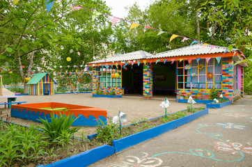Fototapeta na wymiar playground with a veranda, flower beds and game structures