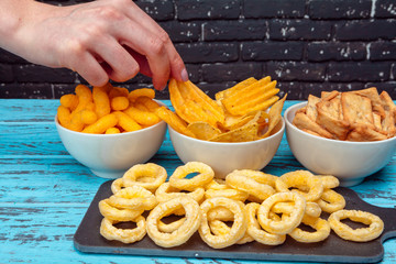 Differnt Types of Junk food, salty-sticks, salty-crackers on wooden table in still-life