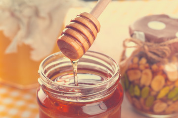 Honey background. Sweet honey in glass jar on wooden background.