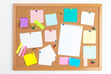 Cork board with several colorful blank notes with pins
