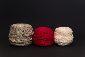 colored knitting yarn and hooks on a black background with space for text