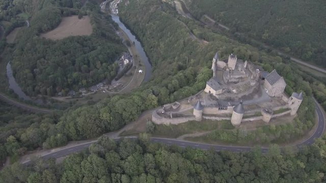 Panning left to right, high above and on the side of Bourscheid castle in Luxembourg. Showing the mountains and the forest. Sunny weather with clouds.