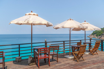 Terrace with chairs and tables under parasol in Thailand.