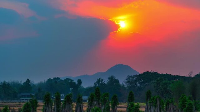 Sunset timelapse with tree foreground and mountain background. Countryside,Thailand.