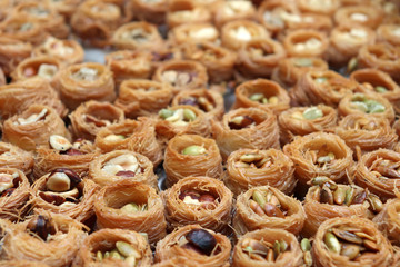 Baklava with nuts, sweet background. Traditional turkish and arabic dessert Kunafa with pistachio, hazelnut and honey