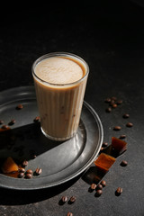 Glass of tasty frappe coffee on dark table