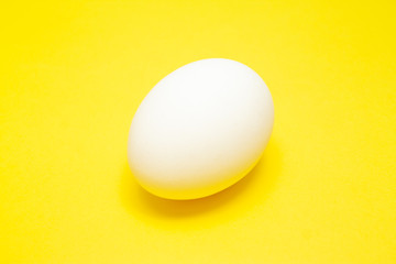 White easter egg on yellow background in center. Design, visual art, minimalism
