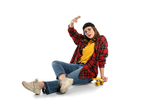 Portrait of beautiful young woman with skateboard on white background