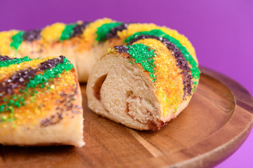 Festive cake for Mardi Gras (Fat Tuesday) holiday on wooden plate, closeup