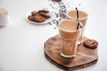 Glasses of tasty frappe coffee on white table