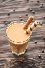 Glass of tasty frappe coffee on wooden table