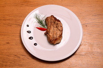 Large piece of rare prime rib with cut vegetables and a baked potato