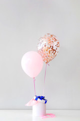 Gift with air balloons on light background