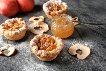 Tasty apple pies on grey table