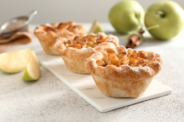 Tasty apple pies on grey table