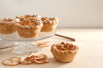 Obraz na płótnie Canvas Dessert stand with tasty apple pies on wooden table