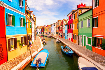Naklejka na ściany i meble Colorful houses in Burano near Venice, Italy with boats, canal and tourists. Famous tourist attraction in Venice.