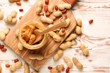Fototapeta na wymiar Jar with tasty peanut butter on white table