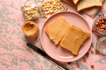 Plate with tasty peanut butter and bread on table