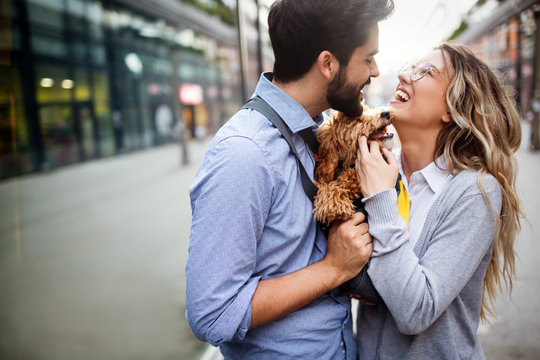 Couple in love with dog walking and smiling outdoor