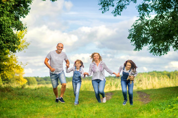 Obraz premium Loving family. Happy young family spending time together having fun in summer park, people concept. Family еnjoying time together