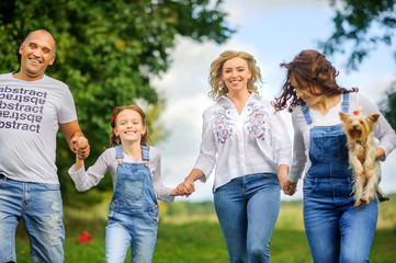 Fototapeta premium Loving family. Happy young family spending time together having fun in summer park, people concept. Family еnjoying time together