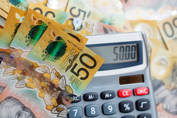 Australian fifty dollar bill over a calculator. The new 2019 issue is designed to deter...